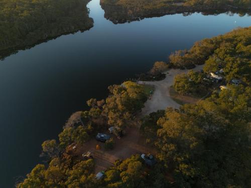 an aerial view of a lake with trees and water at Molloy Holiday Park in Kudardup