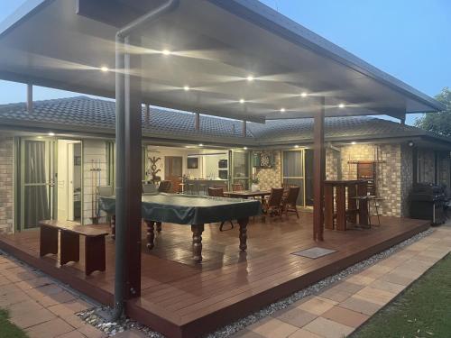 a covered deck with a pool table on it at Pandanus Paradise. Newly renovated 4 bedroom home in Cabarita Beach
