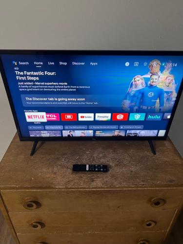 a television on top of a dresser with a remote control at West Phoenix Value Room 1 Bennet in Phoenix