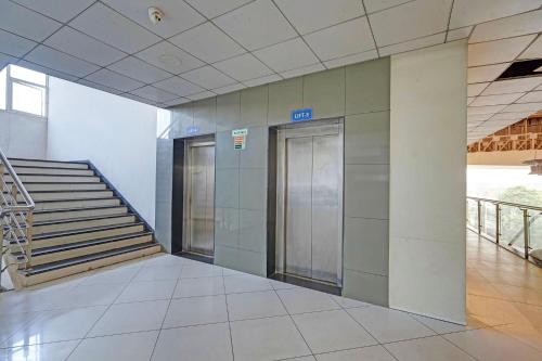 Un pasillo con escaleras y ascensores en un edificio. en FabHotel Stay In, en Vadodara