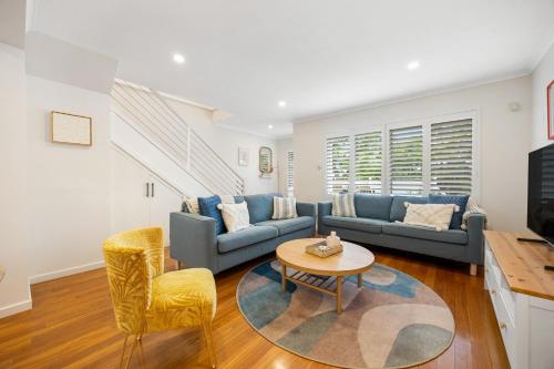 a living room with a couch and a table and chairs at Hazy Shores Escape - Breezy Coastal Stay near Henley Square in Henley Beach