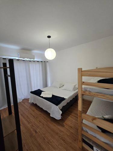 a bedroom with a bed and two bunk beds at Sapucaia Flat - Apart Hotel in Santa Rita do Sapucaí