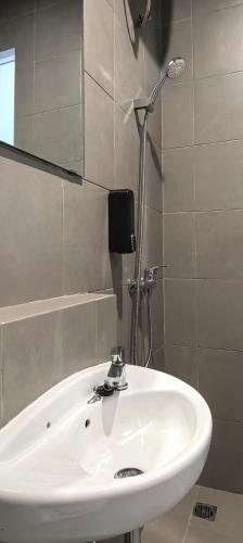 a bathroom with a white sink and a shower at Shencasa Living Juanda in Siwalam 2