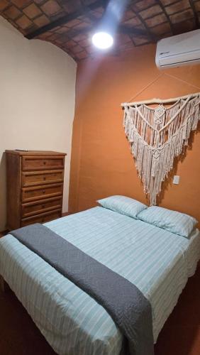 a bedroom with a bed and a dresser at Casita Paraiso Escondido in Peñita de Jaltemba