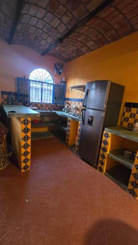 a kitchen with a stainless steel refrigerator and a table at Casita Paraiso Escondido in Peñita de Jaltemba