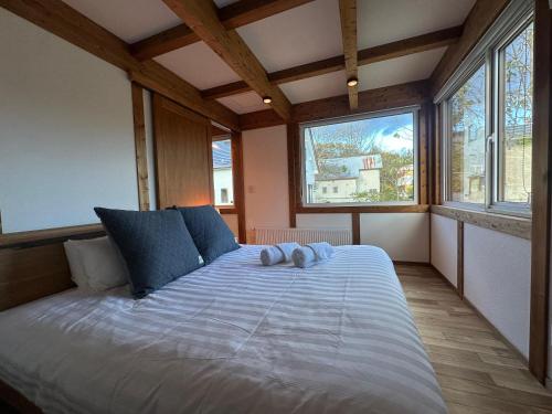 ein Schlafzimmer mit einem großen Bett mit zwei blauen Kissen in der Unterkunft Niseko Annupuri Royal Chalet in Niseko