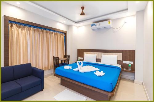 - une chambre avec un lit bleu et un canapé dans l'établissement Jagannath Temple Hometoun Palace Resort - Fully Air Hotel, à Purî