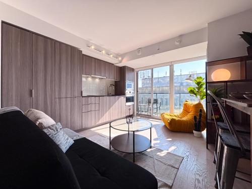 a living room with a couch and a table at DT Cozy 1B1B with Den near UofT and Bay St in Toronto