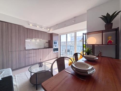 a kitchen and dining room with a wooden table at DT Cozy 1B1B with Den near UofT and Bay St in Toronto