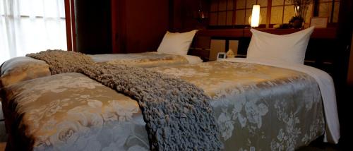 two beds in a hotel room with blankets on them at Private Japanese Modern Onsen Villa Azumino Salon1 in Azumino