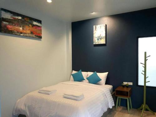 ein Schlafzimmer mit einem weißen Bett mit blauen Wänden in der Unterkunft The Hua Hin Hotel in Hua Hin