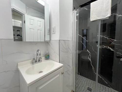 a white bathroom with a sink and a shower at VibeHaus Midtown in New York
