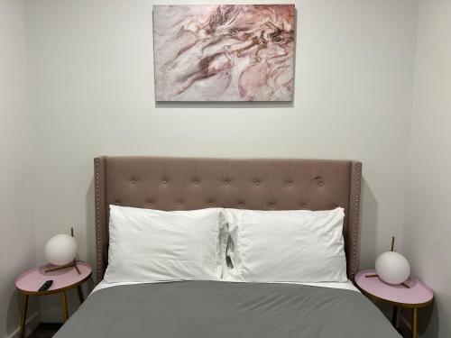 a bedroom with a bed with two lamps on tables at VibeHaus Midtown in New York