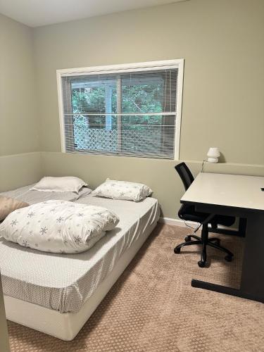 a bedroom with two beds and a desk and a desk at Spacious Basement with independent entry and yard in Issaquah
