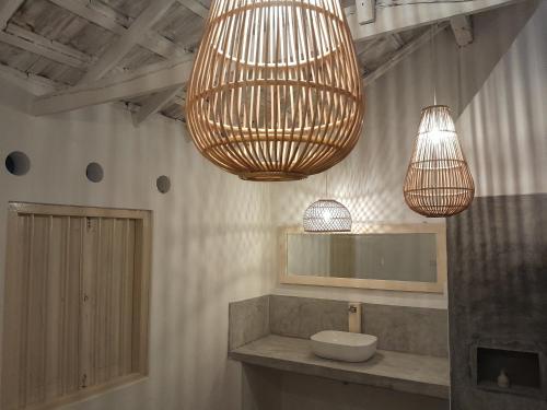 a bathroom with two hanging lights and a sink at Diviya Bungalow and Cantina in Matara