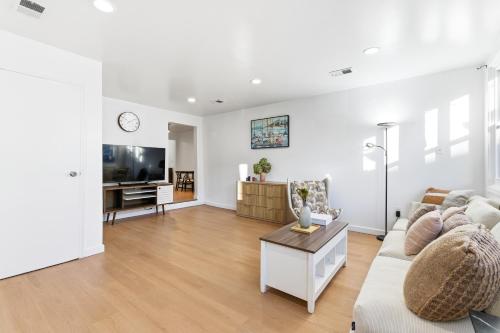 a white living room with a couch and a tv at Hamilton-15 mins to EWR, 20 mins PATH to NYC in Harrison