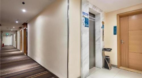 a hallway of a building with a elevator at City Comfort Inn Liuzhou Baisha Bus Station Shengli Barbecue City in Liuzhou