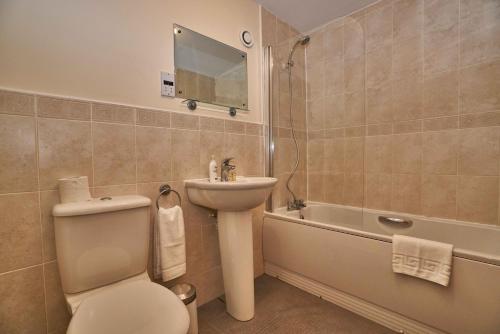 a bathroom with a toilet and a sink and a tub at Haymarket Residence in Edinburgh