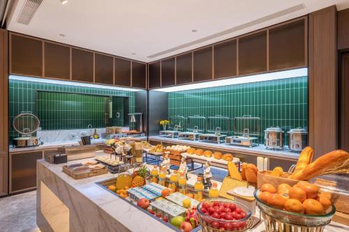 a buffet line in a hotel with fruits and vegetables at Orange Hotel, Longhu Paradise Walk, Daxing Biomedical Base, Beijing in Beijing