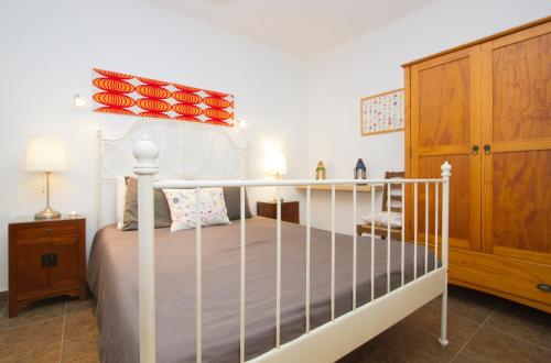Schlafzimmer mit einem weißen Bett und einem Holzschrank in der Unterkunft Casa Hibiscus in Punta de Mujeres