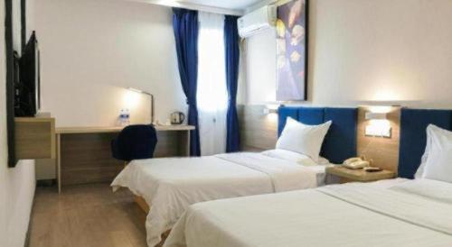 Postel nebo postele na pokoji v ubytování 7 Days Premium Xianning Wenquan Shopping Center