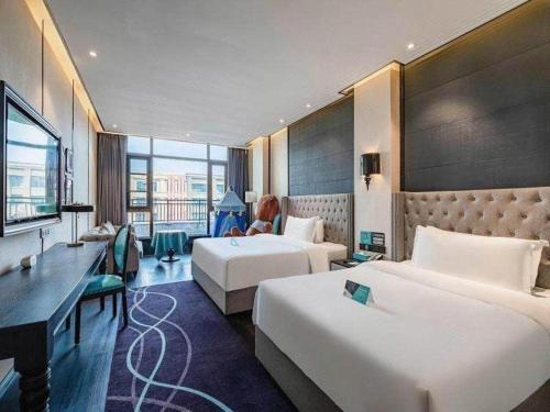 a hotel room with two beds and a desk at Xana Hotelle Luzhou High-Speed Railway Station Trading Market Passenger Terminal in Luzhou