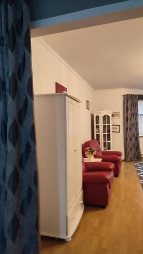 sala de estar con 2 sillas rojas y armario blanco en WloterStyl 1, en Varsovia