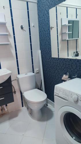 ein Badezimmer mit Toilette und Waschmaschine in der Unterkunft WloterStyl 1 in Warschau