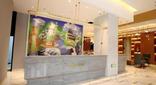 un hall d'entrée avec un grand tableau sur le mur dans l'établissement Magnotel Nanjing Lishui Baota Bei Road, à Lishui