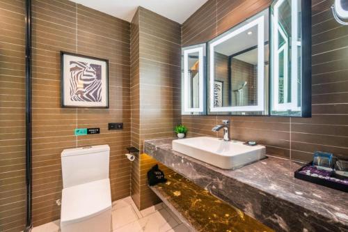 ein Badezimmer mit Waschbecken und Spiegel in der Unterkunft Xana Hotelle Nanchang Tengwang Pavilion Qingshan Road Metro Station in Nanchang County