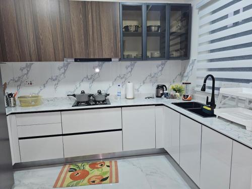 a white kitchen with white cabinets and a sink at Aha 3G in Port Harcourt