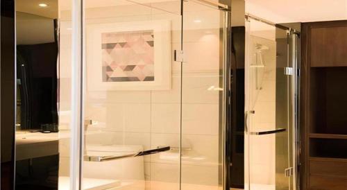 a shower with a glass door in a bathroom at Borrman Hotel Huanggang Wuxue Yuhu Road in Wuxue