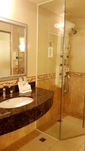 a bathroom with a sink and a shower at Wonderful Hall Hotel in Xinzhuang