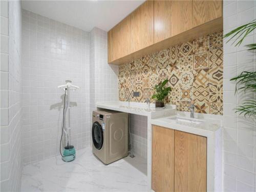 a bathroom with a washing machine and a sink at Magnotel Hotel Suzhou Wanda Plaza Huaihai Road in Suzhou