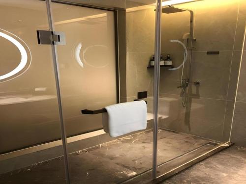 ein Badezimmer mit Dusche mit Glastür in der Unterkunft E-Cheng Hotel Liuzhou Sanjiang Fengyu Bridge in Sanjiang