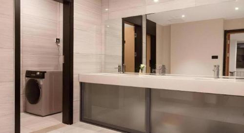 ein Badezimmer mit 2 Waschbecken und einer Waschmaschine in der Unterkunft Green Tree Inn Nanchang Zhongshan Road Bayiguan in Nanchang
