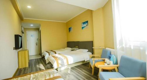 ein Hotelzimmer mit zwei Betten und einem Fernseher in der Unterkunft GreenTree Alliance Hotel Qinghuangdao Wanda Plaza in Qinhuangdao