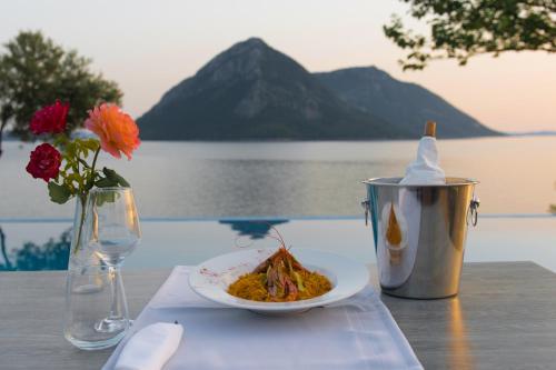 a table with a plate of food and a drink at Thesmos Village in Mýtikas