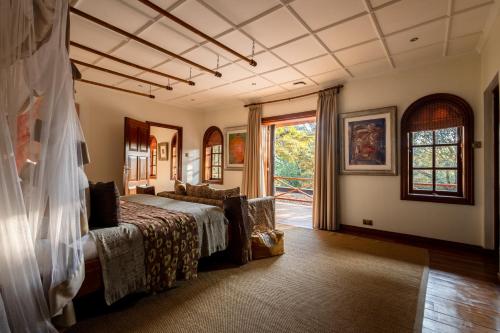 a bedroom with a bed and a large window at Hemingways Eden Residence in Nairobi