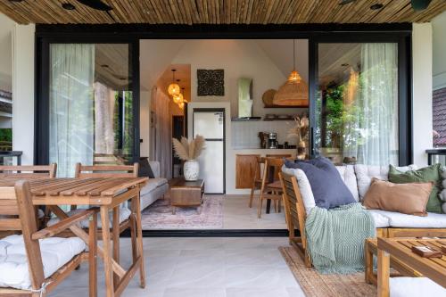 ein Wohnzimmer mit Tisch und Couch in der Unterkunft The Tropical Boho Bungalow in Phra Ae beach