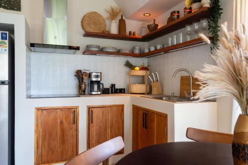 eine Küche mit Holzschränken und einem Tisch in der Unterkunft The Tropical Boho Bungalow in Phra Ae beach