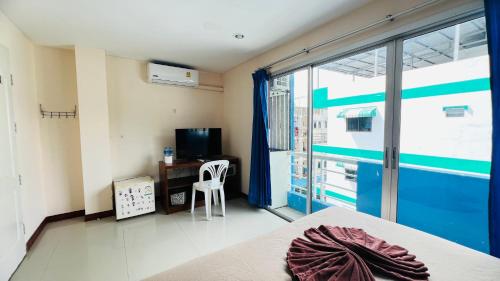 Lucky One Guesthouse في شاطيء باتونغ: غرفة بها سرير ومكتب ونافذة
