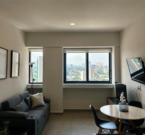 a living room with a couch and a table and a window at Departamento Lafayette, cerca de Chapultepec, CAS, Minerva in Guadalajara
