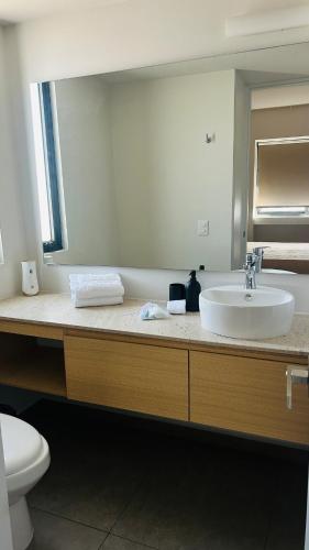 a bathroom with a sink and a toilet and a mirror at Departamento Lafayette, cerca de Chapultepec, CAS, Minerva in Guadalajara