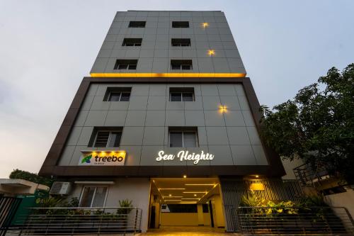 un edificio alto con un cartel en él en Treebo Sea Heights, en Kākināda