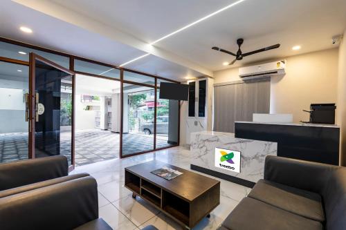 una sala de estar con un sofá y una mesa en Treebo Sea Heights, en Kākināda