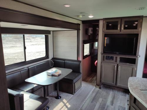 Una sala de estar con una mesa y un televisor. en Laqa comp Oman - مخيم لقى عُمان, 