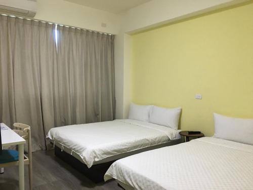 a hotel room with two beds and a window at Siang Jhan B&B in Taitung City