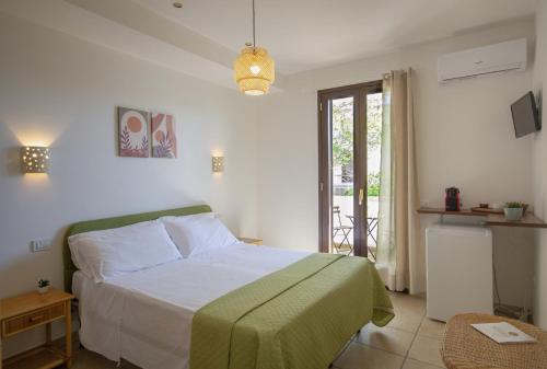 een slaapkamer met een bed met witte lakens en een raam bij Residence Borgo Latino- Localo in Torre dell'Orso