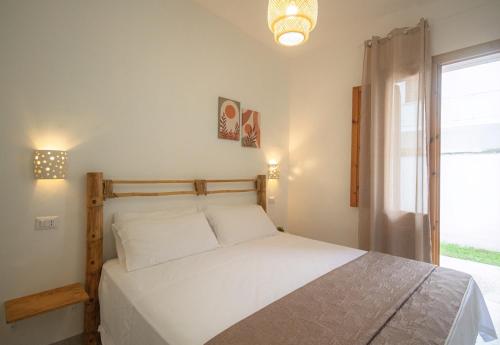 a bedroom with a white bed and a window at Residence Borgo Latino- Localo in Torre dell'Orso